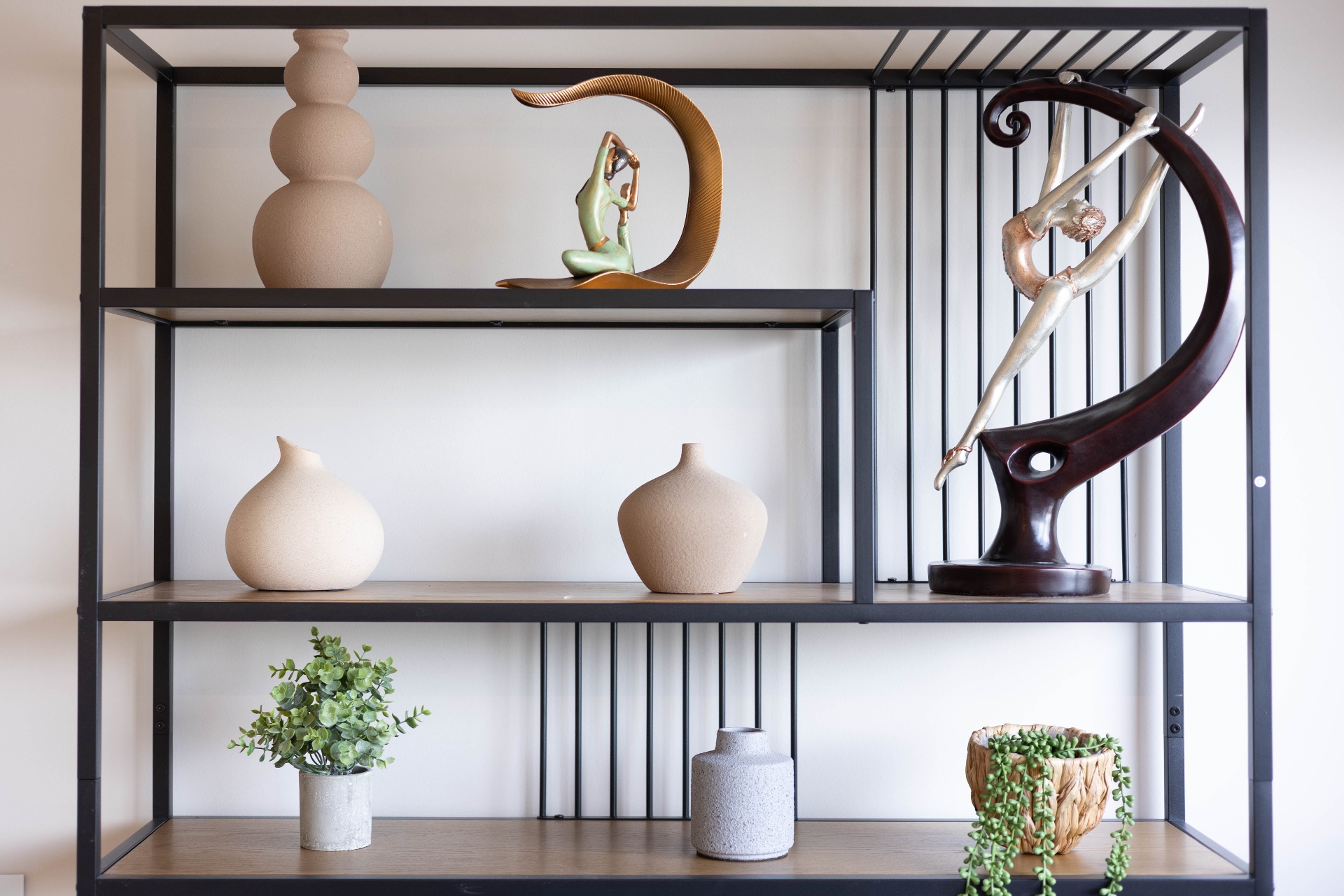 Ceramic vases and dancer figurines on the metal shelf in the dining area