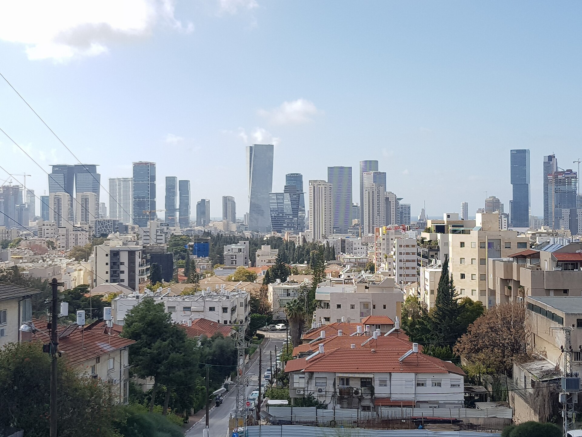 Givatayim from Kozlovsky Hill: tiled roofs, trees, and the Tel Aviv towers on the horizon
