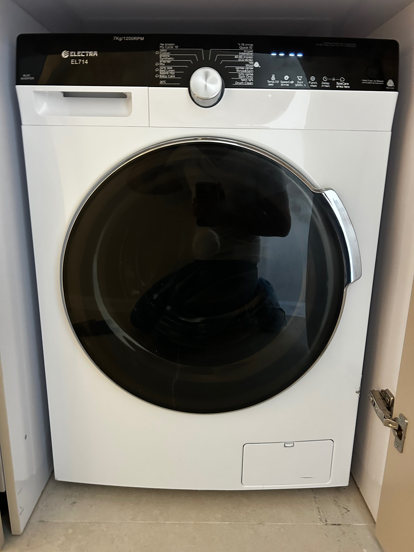 The washing machine in the apartment's laundry closet